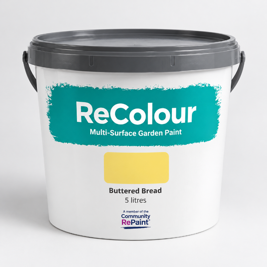 A 5-liter plastic bucket of ReColour Multi-Surface Garden Paint in the color 'Buttered Bread'. The bucket is white with a dark gray lid and handles, featuring a teal label with a yellow color swatch.