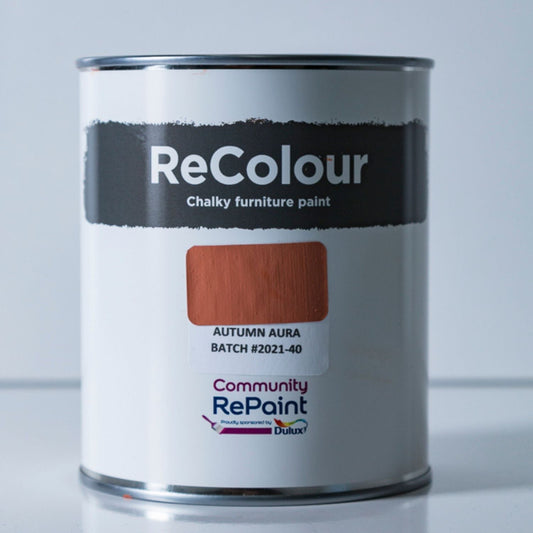 A can of ReColour Chalky furniture paint in the Autumn Aura shade, featuring a white label with a brown color swatch and the Community RePoint Dulux logo.