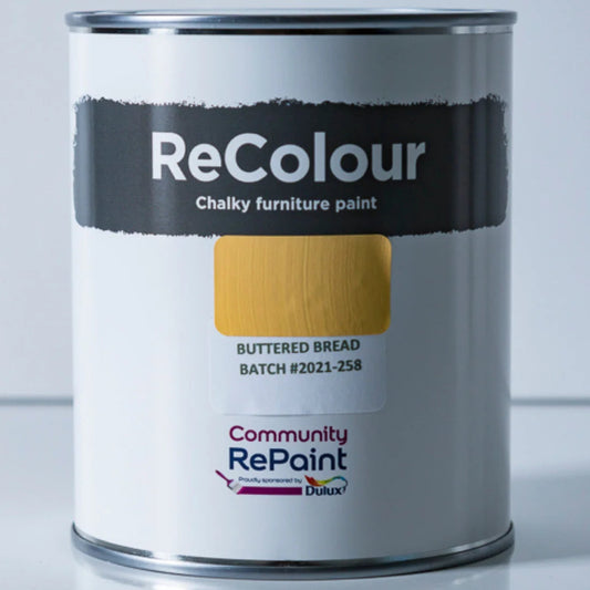 A can of ReColour Chalky furniture paint in the Buttered Bread color, showing a textured yellow-gold paint swatch on the label. The can features the ReColour brand name in white text on a black band, and the Community RePaint by Dulux logo at the bottom.